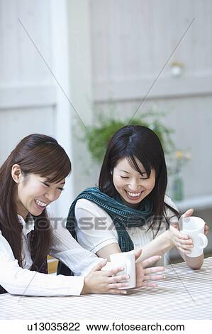 Stock Image - Two Young Women Drinking Tea. Fotosearch