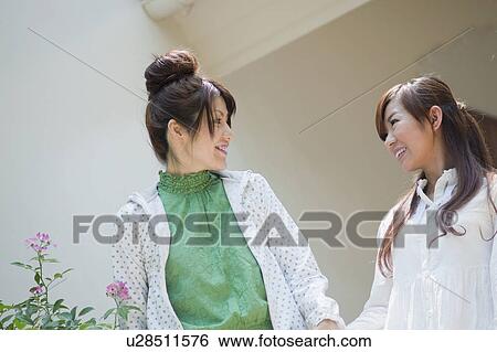 Stock Photograph - Two Young Women Looking at Each Other. Fotosearch