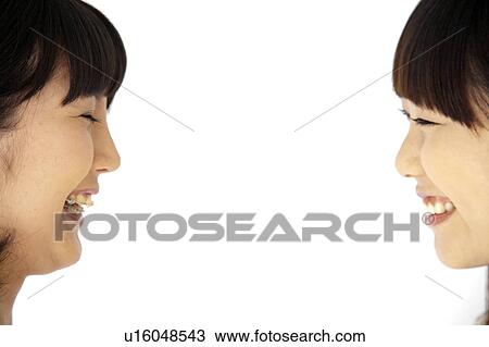 Stock Image - Two Young Women Smiling at Each Other. Fotosearch
