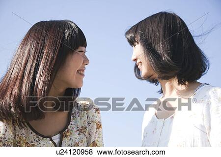 Two Young Women Smiling at Each Other View Large Photo Image Stock Photo - Two Young Women Smiling at Each Other. Fotosearch