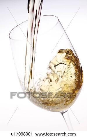 Stock Image - White wine being poured into wineglass. Fotosearch