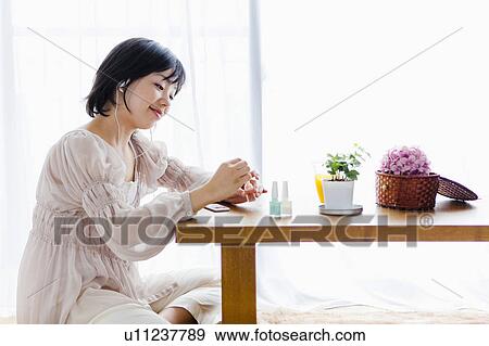 Woman Doing her Nails and Listening to Mp3 Player View Large Photo Image Stock Photo - Woman Doing her Nails and Listening to Mp3 Player. Fotosearch