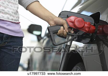 Stock Image - Woman filling car in gas station, close up. Fotosearch