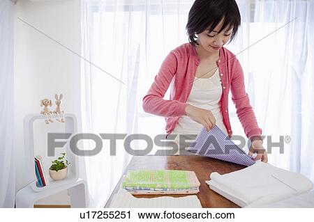Stock Image - Woman Folding Clean Clothes. Fotosearch