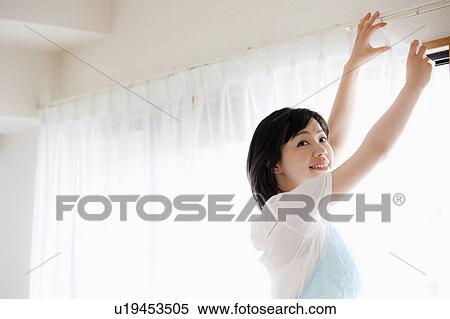 Woman Hanging up Curtains View Large Photo Image Stock Photography - Woman Hanging up Curtains. Fotosearch