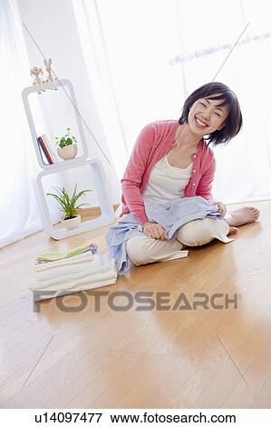 Woman Sitting on Floor With Folded Clothes View Large Photo Image Stock Photo - Woman Sitting on Floor With Folded Clothes. Fotosearch