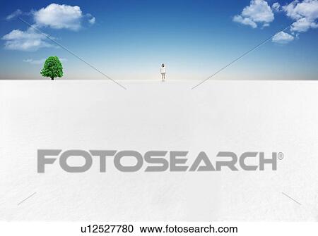 Stock Image - Woman standing in snowy land, copy space. Fotosearch