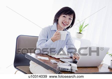 Stock Photo - Woman Working at Desk. Fotosearch