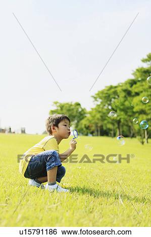 Young Boy Blowing Soap Bubbles in Park View Large Photo Image Stock Photograph - Young Boy Blowing Soap Bubbles in Park. Fotosearch