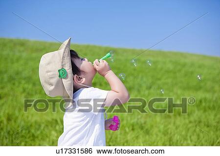 Stock Photograph - Young Boy Blowing Soap Bubbles. Fotosearch