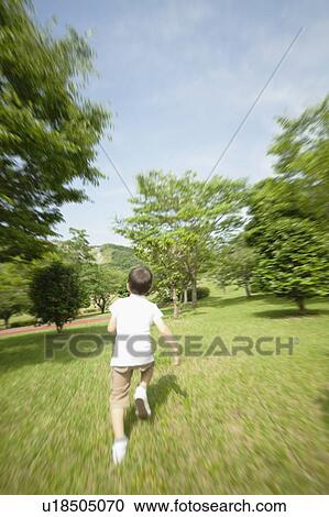 Stock Image - Young Boy Running in Park. Fotosearch