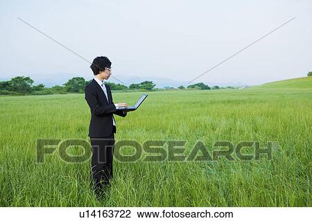 Young Businessman Using Laptop in Field View Large Photo Image Stock Image - Young Businessman Using Laptop in Field. Fotosearch
