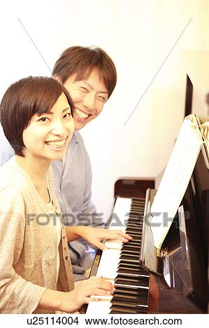 Picture - Young Couple Playing the Piano Together. Fotosearch