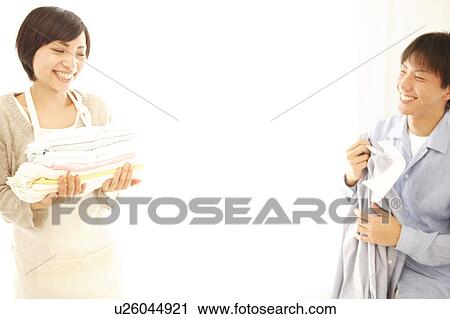 Stock Image - Young Couple Putting the Laundry Away . Fotosearch