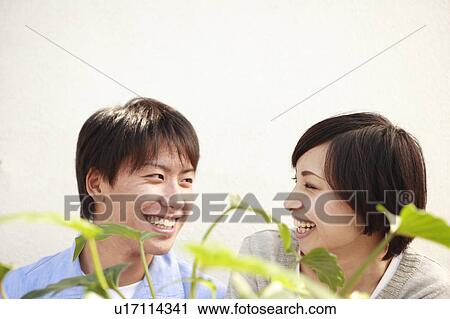 Stock Image - Young Couple Smiling at Each Other. Fotosearch