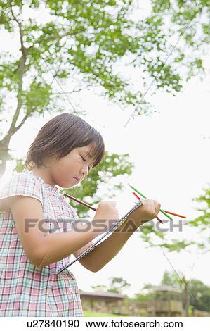 Stock Image - Young Girl Drawing Outdoors. Fotosearch