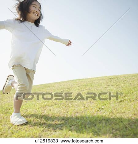 Stock Image - Young Girl Running in Grass. Fotosearch