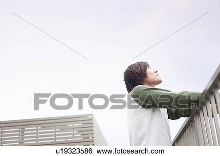 Young man looking up on a rooftop, Japan View Large Photo Image Stock Photograph - Young man looking up on a rooftop, Japan. Fotosearch