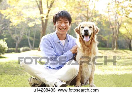 Stock Image - Young Man Sitting with Dog. Fotosearch