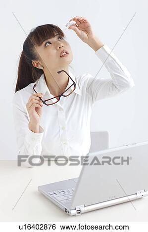 Stock Photograph - Young woman applying eye drops, white background. Fotosearch