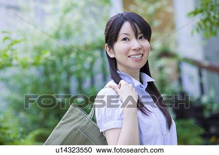 Stock Image - Young Woman Carrying Handbag. Fotosearch