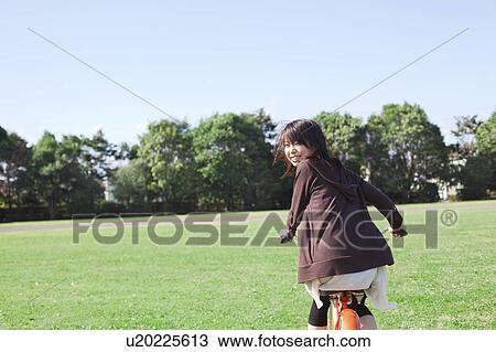 Young woman cycling at park, Japan View Large Photo Image Stock Image - Young woman cycling at park, Japan. Fotosearch