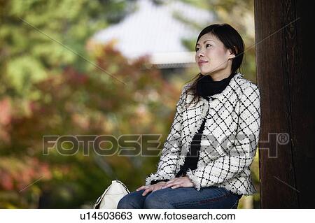 Stock Image - Young Woman Daydreaming Outdoors. Fotosearch
