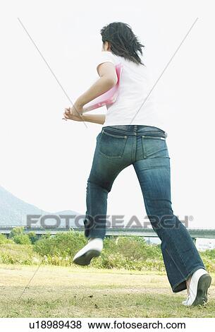 Young woman holding a file and running View Large Photo Image Stock Photo - Young woman holding a file and running. Fotosearch