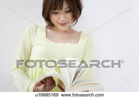 Young woman holding book, turning pages, white background, blurred motion View Large Photo Image Stock Photo - Young woman holding book, turning pages, white background, blurred motion. Fotosearch