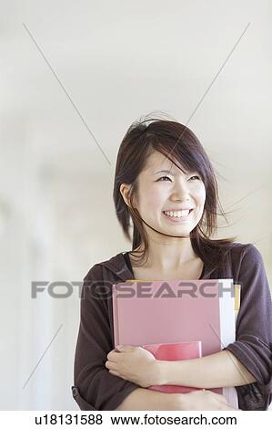 Young woman holding books, Japan View Large Photo Image Stock Photo - Young woman holding books, Japan. Fotosearch