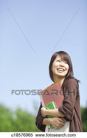 Stock Photography - Young woman holding books, Japan. Fotosearch