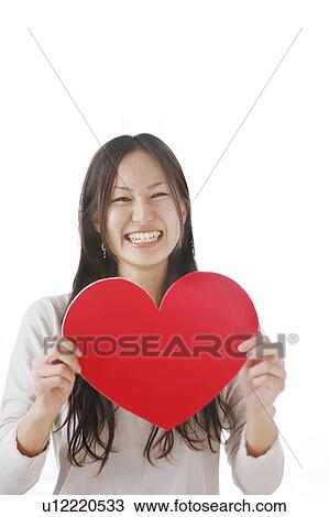 Stock Image - Young Woman Holding Red Heart. Fotosearch