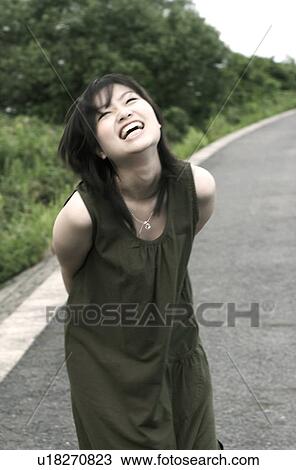 Stock Image - Young woman in a dress laughing . Fotosearch