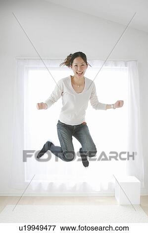 Stock Photo - Young Woman Jumping in the Room. Fotosearch