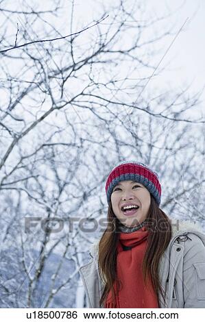 Stock Photograph - Young Woman Laughing Near Snowy Trees. Fotosearch