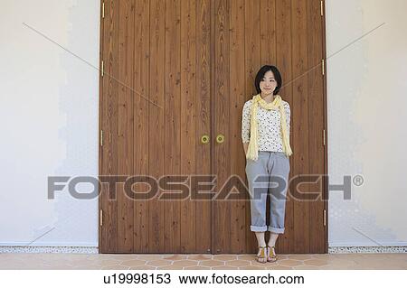 Young Woman Leaning on Double Wooden Doors View Large Photo Image Stock Image - Young Woman Leaning on Double Wooden Doors. Fotosearch