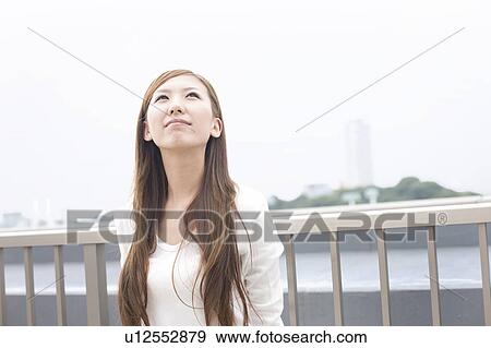 Young woman looking up on rooftop, Japan View Large Photo Image Stock Photo - Young woman looking up on rooftop, Japan. Fotosearch