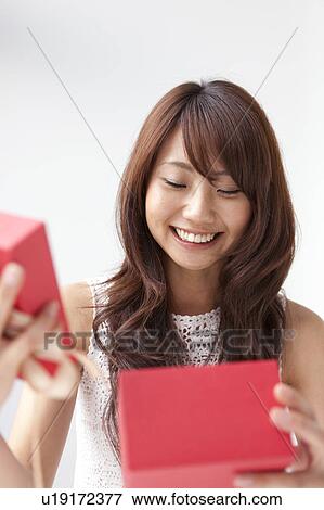 Young woman opening present box, white background View Large Photo Image Stock Photo - Young woman opening present box, white background. Fotosearch