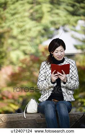 Young Woman Reading Outdoors View Large Photo Image Picture - Young Woman Reading Outdoors. Fotosearch