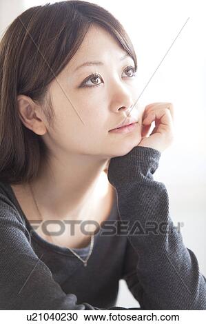 Stock Image - Young Woman Resting Her Chin in Her Hand. Fotosearch