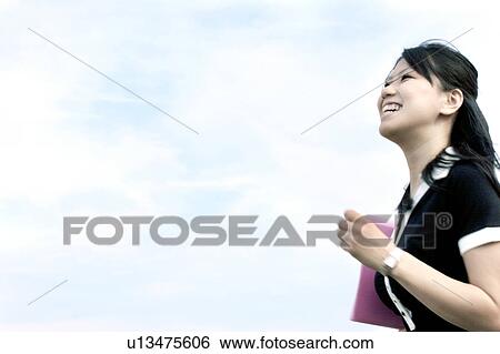 Stock Photograph - Young woman running and smiling. Fotosearch