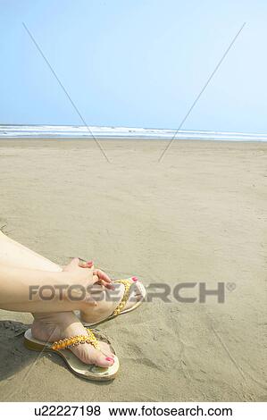 Young woman sitting on beach View Large Photo Image Stock Photo - Young woman sitting on beach. Fotosearch