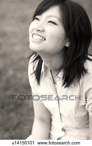 Young woman sitting on bench looking up View Large Photo Image Stock Image - Young woman sitting on bench looking up. Fotosearch