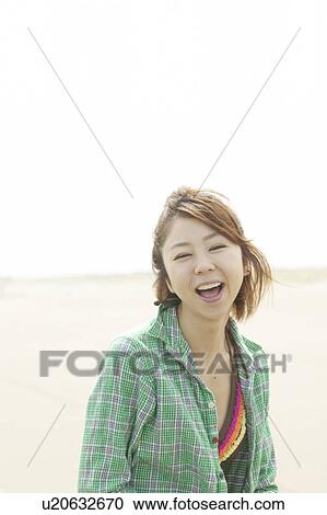 Young woman smiling at beach View Large Photo Image Stock Image - Young woman smiling at beach. Fotosearch