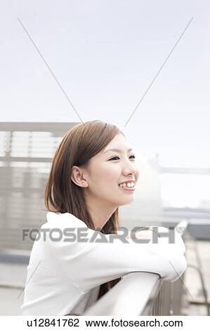 Young woman smiling on rooftop, Japan View Large Photo Image Stock Image - Young woman smiling on rooftop, Japan. Fotosearch