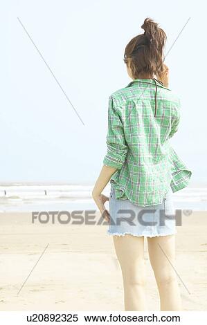 Young woman standing at beach View Large Photo Image Stock Photography - Young woman standing at beach. Fotosearch