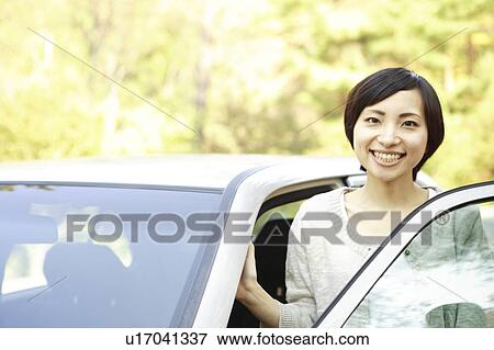 Stock Photo - Young Woman Standing by the Car. Fotosearch