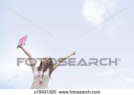 Young woman stretching under sky, smiling, copy space View Large Photo Image Stock Image - Young woman stretching under sky, smiling, copy space. Fotosearch