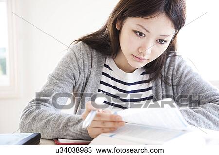 Stock Image - Young Woman Studying at Desk. Fotosearch