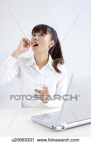 Young woman taking pill, white background View Large Photo Image Stock Image - Young woman taking pill, white background. Fotosearch